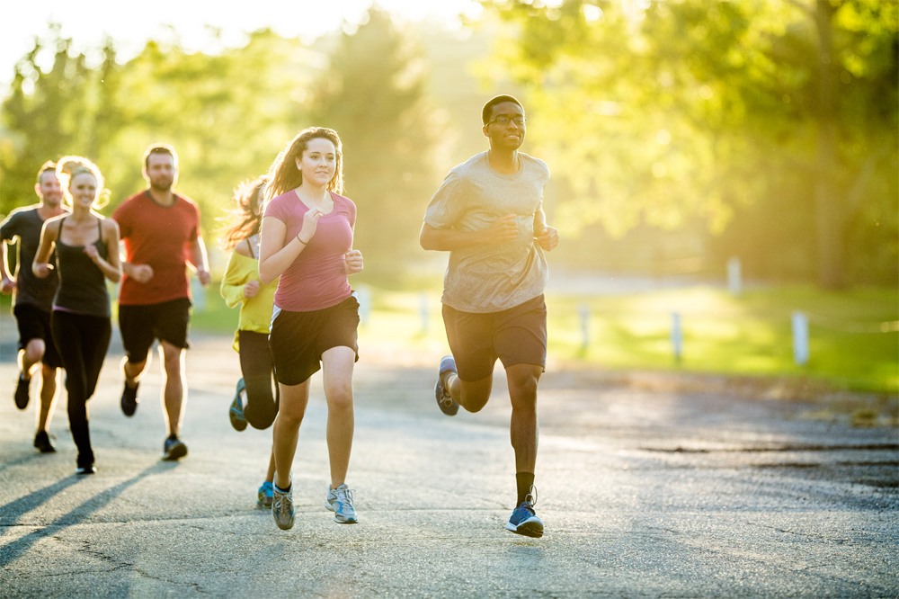 Group of people jogging outdoors on a sunny day.