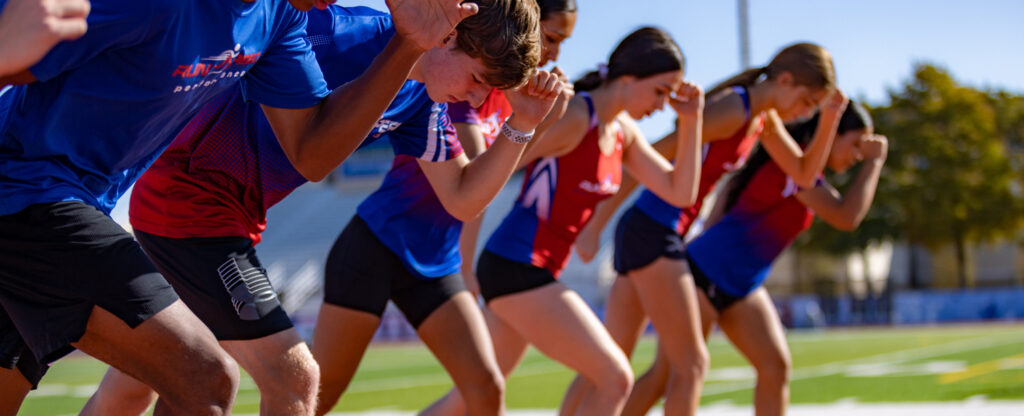 Sprinters poised at track starting line